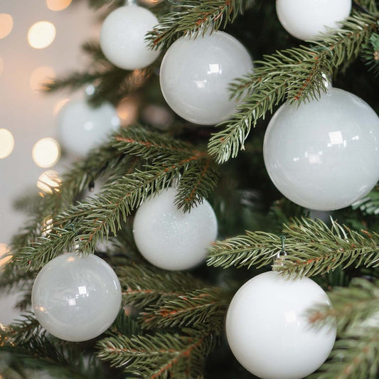 White set Christmas baubles in storage tube